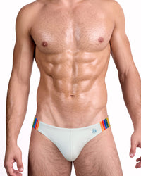 DC2 Mixtape Stripes Swim Mini Brief — model wearing light grey low-rise swim brief featuring multicolor rainbow side stripe panels and signature DC2 logo badge.