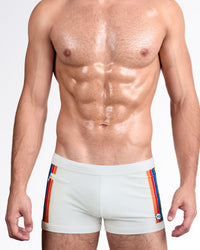 DC2 Mixtape Stripes — model wearing Mixtape Stripes Swim Trunks in soft sand featuring vertical multicolor racing stripes and tailored silhouette.