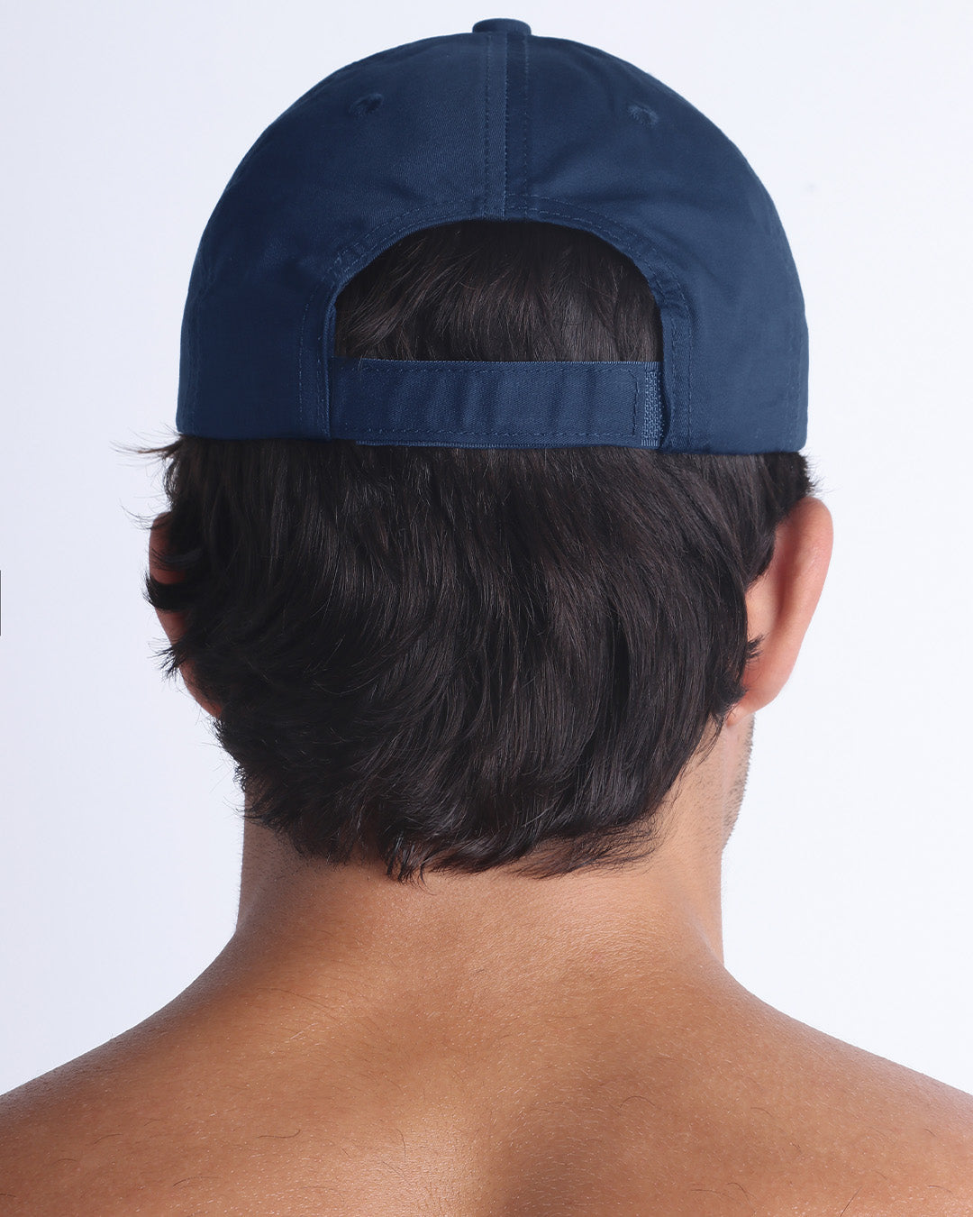 The NAVY BLUE Chillax Cap, modeled here, is in blue. Its adjustable velcro strap at the back ensures a perfect fit for any head size.