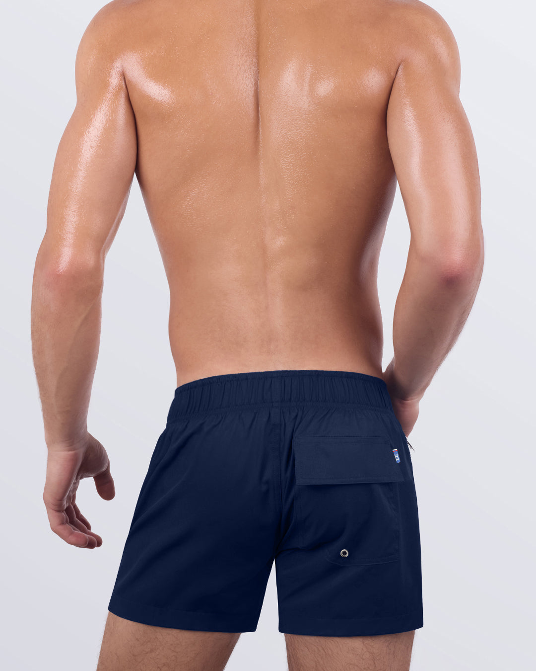 Back view of the NAVY BOOMER - Flex Shorts, showcasing the secure back pocket with a signature logo patch, along with an elasticated waistband for enhanced comfort.
