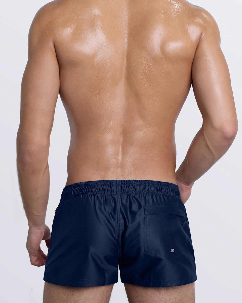 Back view of Navy Boomer Poolside Shorts featuring rear logo patch and water-drain grommet detail.