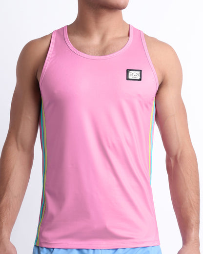 Male model wearing men’s PADAM PINK men’s Summer Tank Top in a pink color with stylish pastel yellow and aqua colored stripes. This high-quality shirt is by DC2, a men’s beachwear brand from Miami.