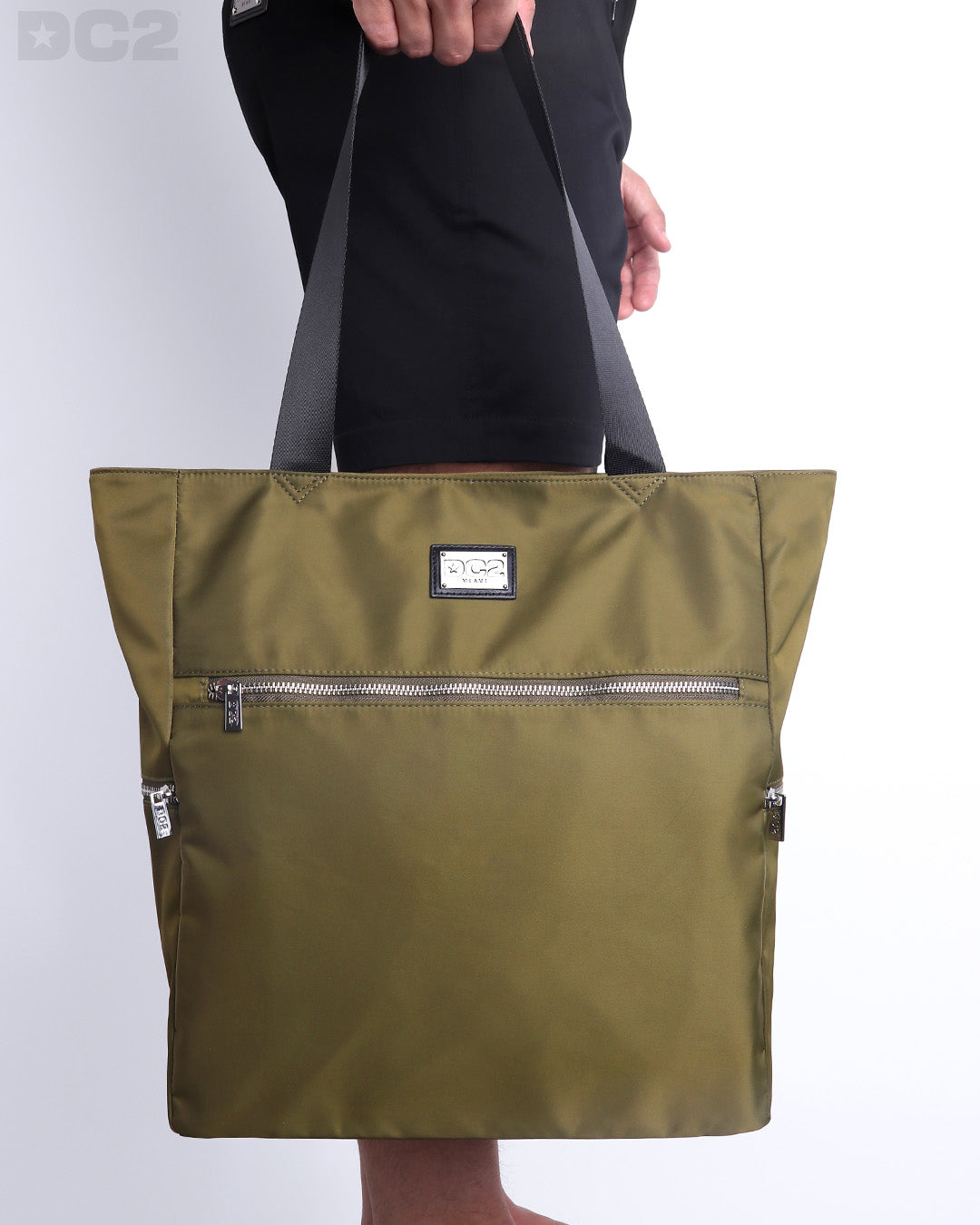 The PALM GREEN Poolside Tote Bag in a olive green color. This perfect day tripper bag protect your belongings from spills and splashes designed by DC2 in Miami.