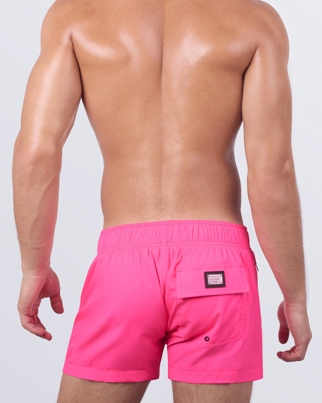 A back view of the PINK BOMB - Flex Shorts, showing the elasticized back waistband, a secure back pocket with a branded patch, and a streamlined silhouette.