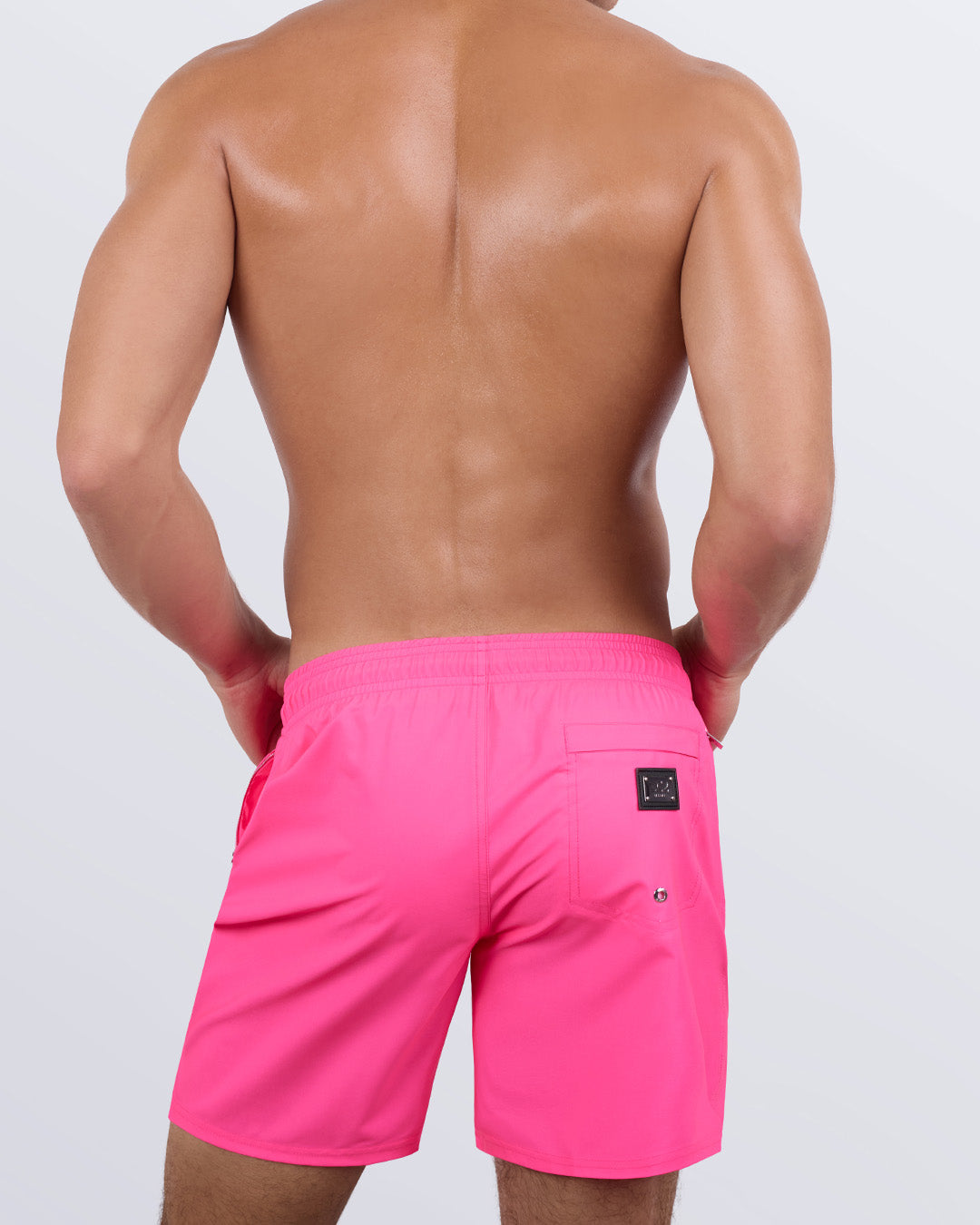 Back view of the PINK BOMB beach Resort Shorts in a solid pink color, complete with a back pocket, designed by DC2 a capsule brand by BANG! Clothes based in Miami.