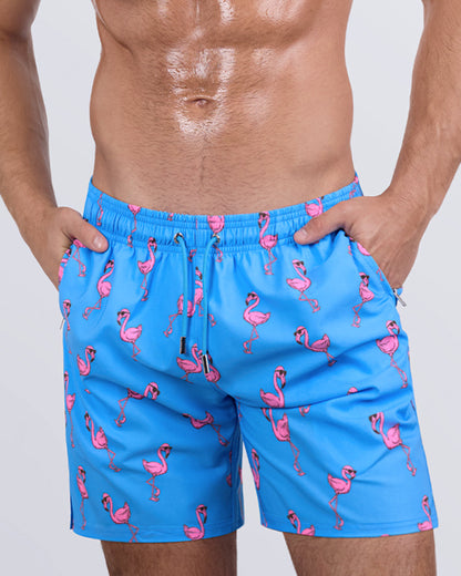 Close-up side view of a male model in the PINK FLAMINGOS Resort Shorts for men by DC2 Miami. These stylish swim shorts feature premium four-way stretch fabric, metallic zip pockets for secure storage, and water-resistant properties for a seamless transition from the beach to the streets.