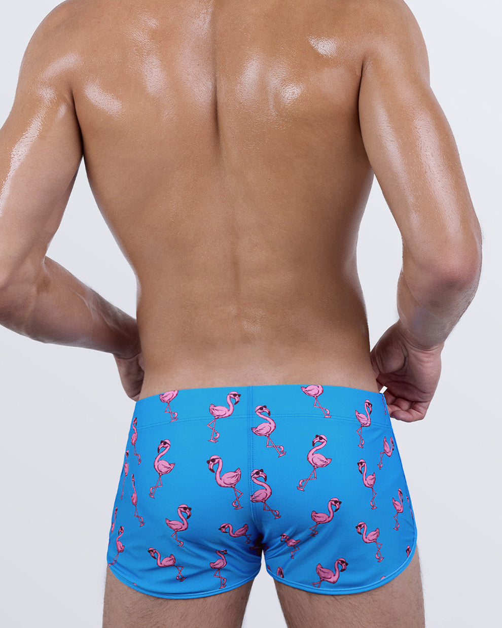 Back view of the PINK FLAMINGOS Swim Shorts – bold contrast of bright pink flamingos on blue, cut for a sculpted, snug fit.