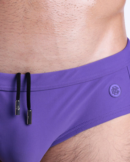 Close-up view of the PURPLE MACHINE men’s drawstring briefs showing black cord with custom branded metallic silver cord ends, and matching custom eyelet trims in silver.