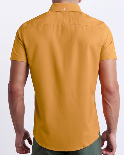 A male model is seen from the back wearing a white RETRO MUSTARD a Hawaiian shirt from DC2, a Miami-based men’s beachwear brand. 