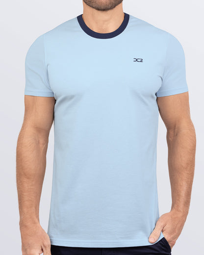 Frontal view of a male model wearing a light blue Pima cotton t-shirt with a bold navy blue collar, crafted for stylish casual wear and beachwear by DC2 Miami. Premium quality men's streetwear t-shirt, perfect fit for summer fashion.