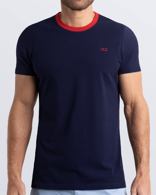 Frontal view of a male model wearing a navy blue Pima cotton t-shirt with a bold red collar, crafted for stylish casual wear and beachwear by DC2 Miami. Premium quality men's streetwear t-shirt, perfect fit for summer fashion.