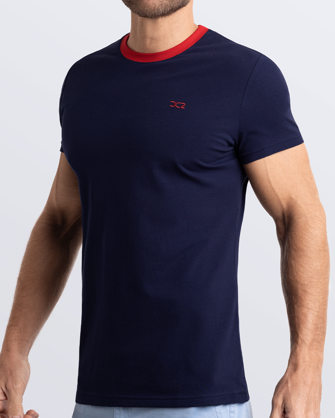 Side view of a men's premium navy blue Pima cotton t-shirt with a contrasting red collar and embroidered DC2 logo. Perfect for a modern casual look, this streetwear tee is part of the DC2 Miami men's beachwear collection, designed for comfort and style.