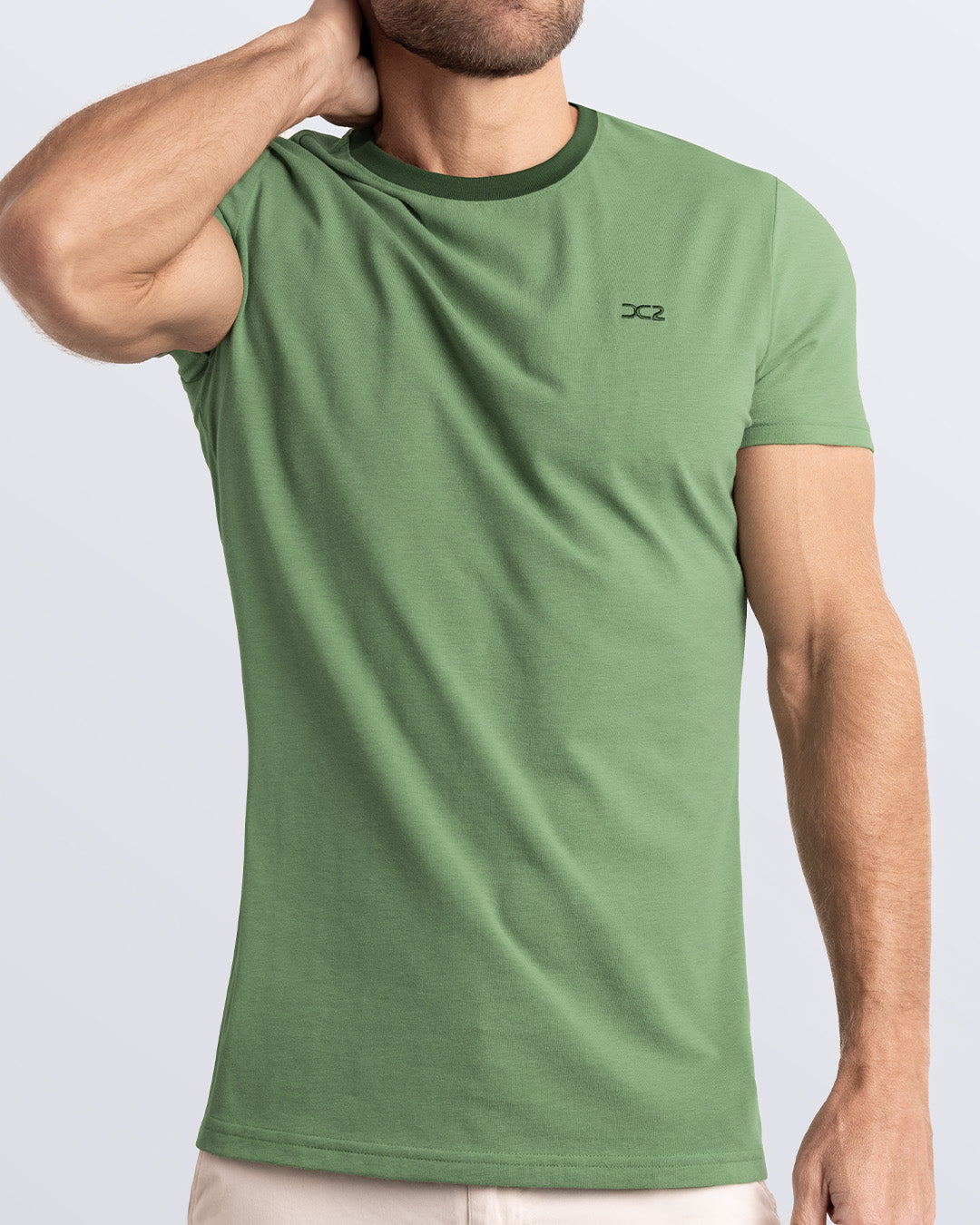 A model wearing the RING ON IT GREEN, a green Pima cotton t-shirt with a bold dark green collar, showcasing the breathable, lightweight fabric ideal for summer beachwear and street style. Part of the DC2 Miami men's casual collection, featuring a perfect fit for active wear