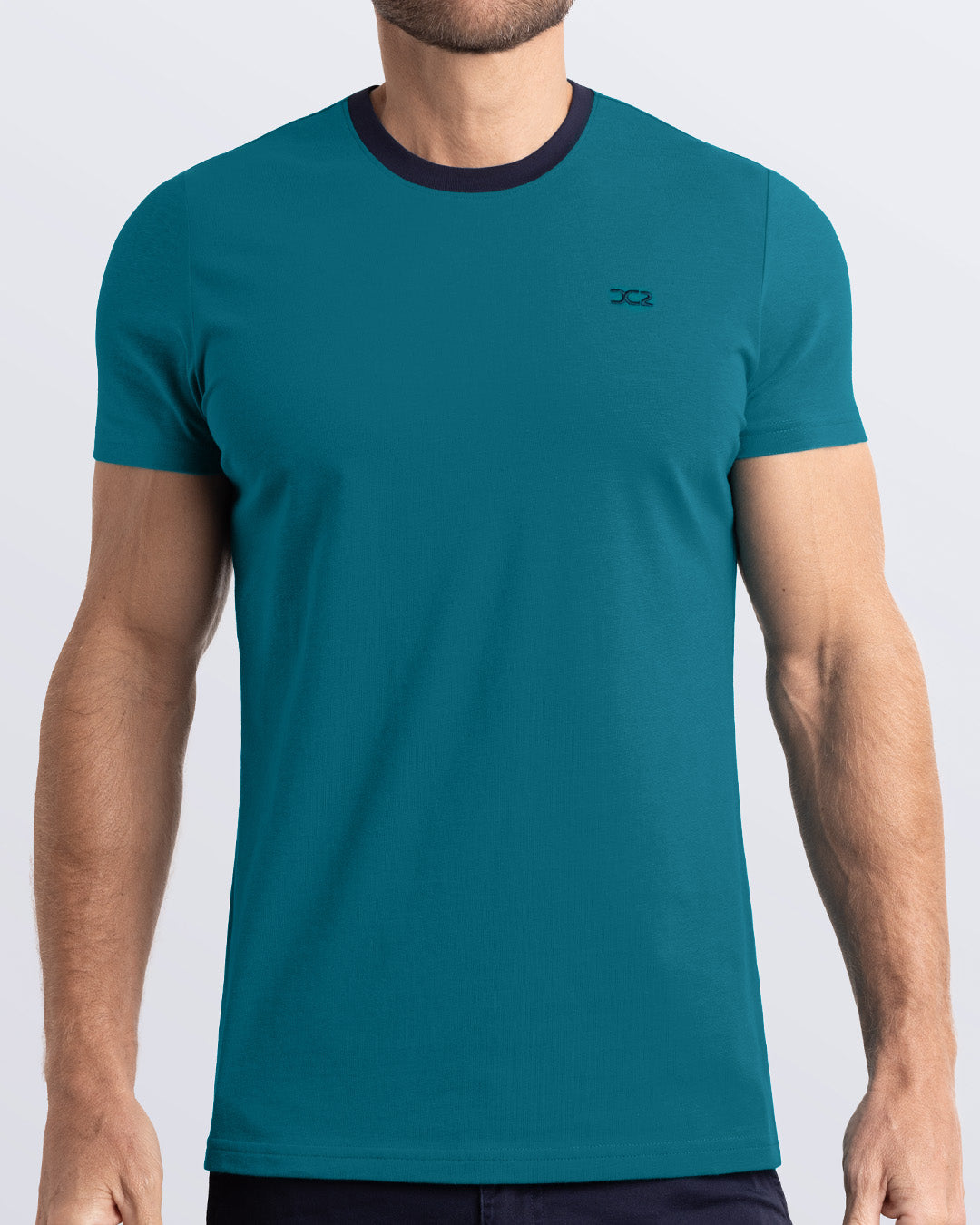 Frontal view of a male model wearing a rich teal Pima cotton t-shirt with a bold navy blue collar, crafted for stylish casual wear and beachwear by DC2 Miami. Premium quality men's streetwear t-shirt, perfect fit for summer fashion.