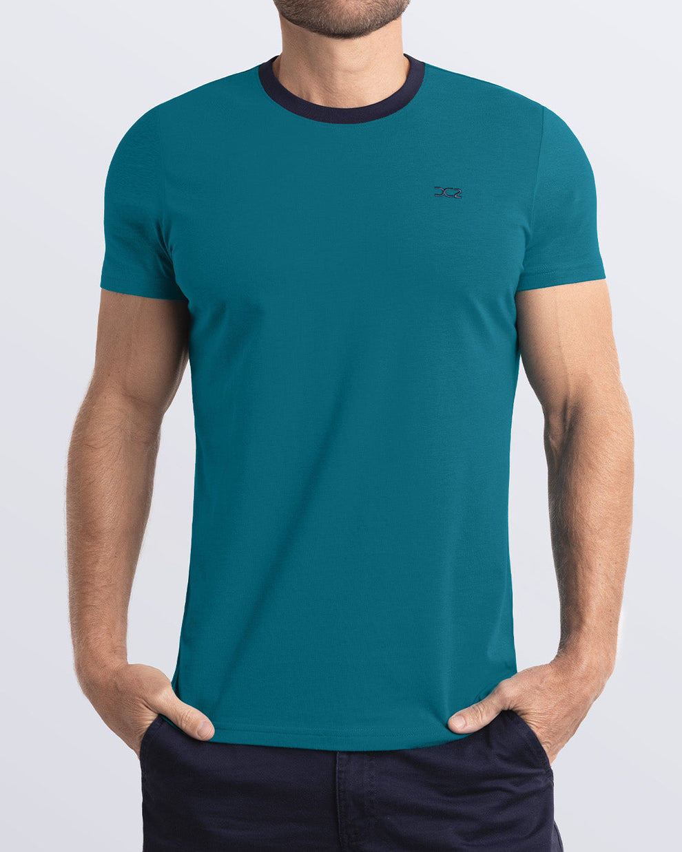 A model wearing the RING ON IT TEAL, a teal Pima cotton t-shirt with a bold dark blue collar, showcasing the breathable, lightweight fabric ideal for summer beachwear and street style. Part of the DC2 Miami men's casual collection, featuring a perfect fit for active wear.