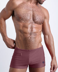DC2 SANDBAR RED Swim Trunks — model wearing square-cut swim trunks in deep red hue, featuring skin-hugging fit and sleek silhouette.