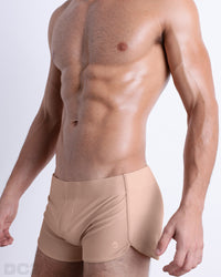 Side view of men’s Summer vintage 80s sprint shorts in SKINNY DIP a solid light beige color made by Miami based Bang capsule brand, DC2.