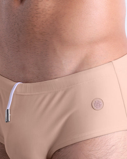 Close-up view of the SKINNY DIP men’s drawstring briefs showing white cord with custom branded metallic silver cord ends, and matching custom eyelet trims in silver.