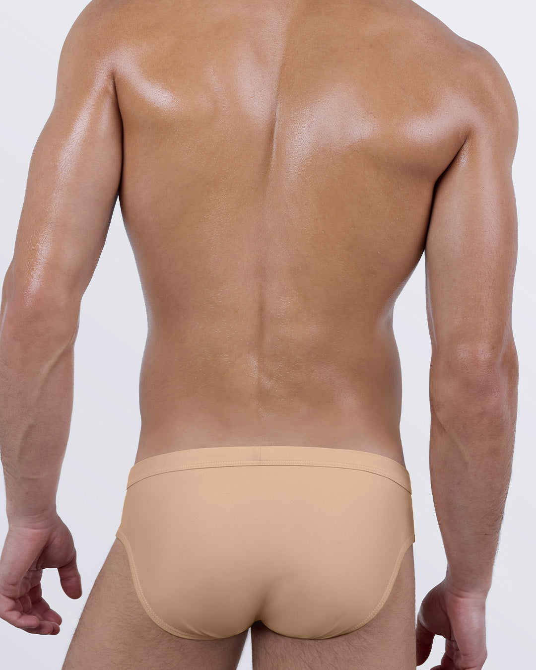 Back view of SKINNY DIP (MEDIUM) men’s swim briefs, featuring full rear coverage in a natural beige hue. Designed with a low-rise seat and snug, second-skin fit that molds to the body’s shape for a confident, streamlined finish.