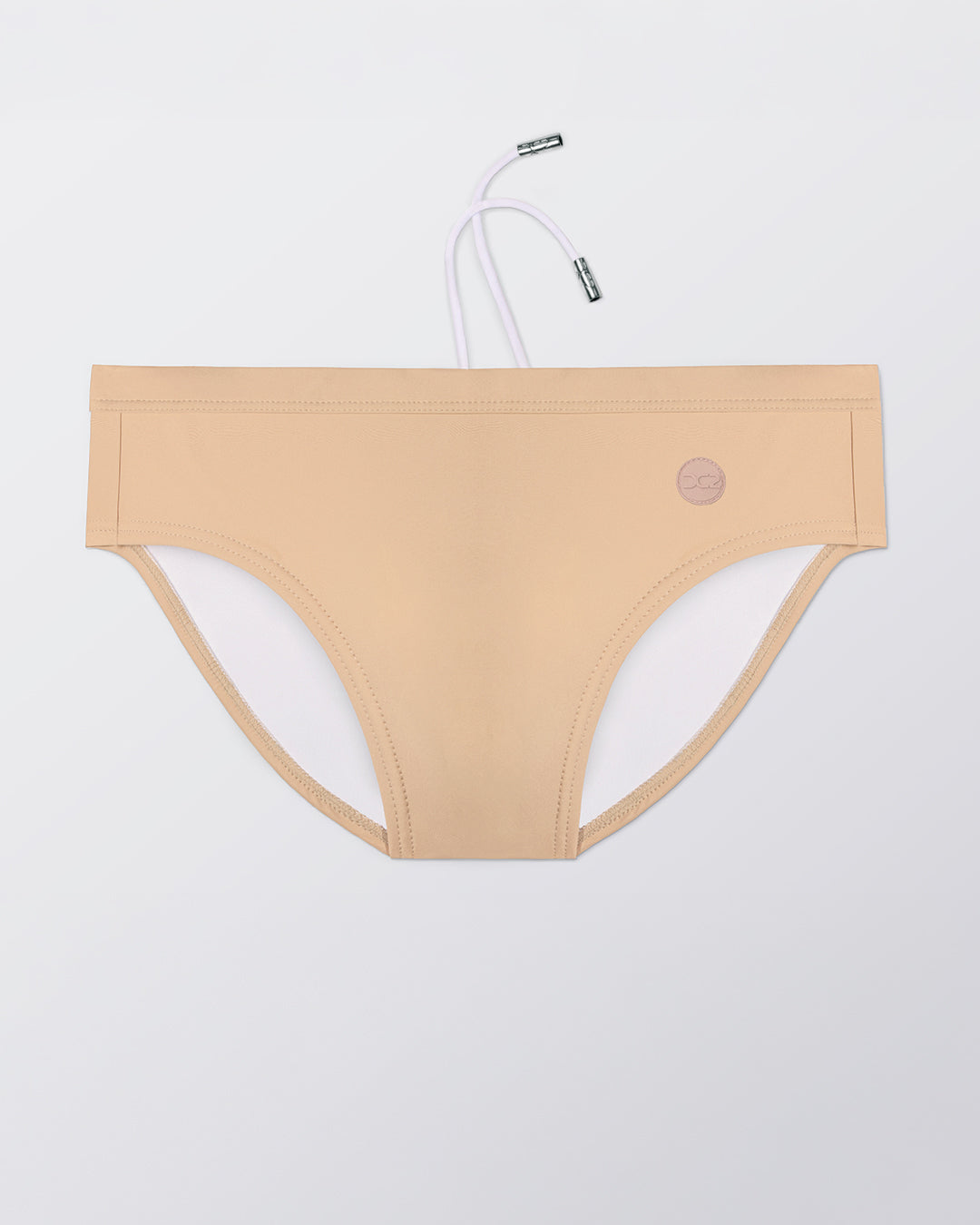 Flat lay of the DC2 Skinny Dip (Medium) Swim Brief, featuring a warm neutral tone and sleek, sculpted swim brief design.