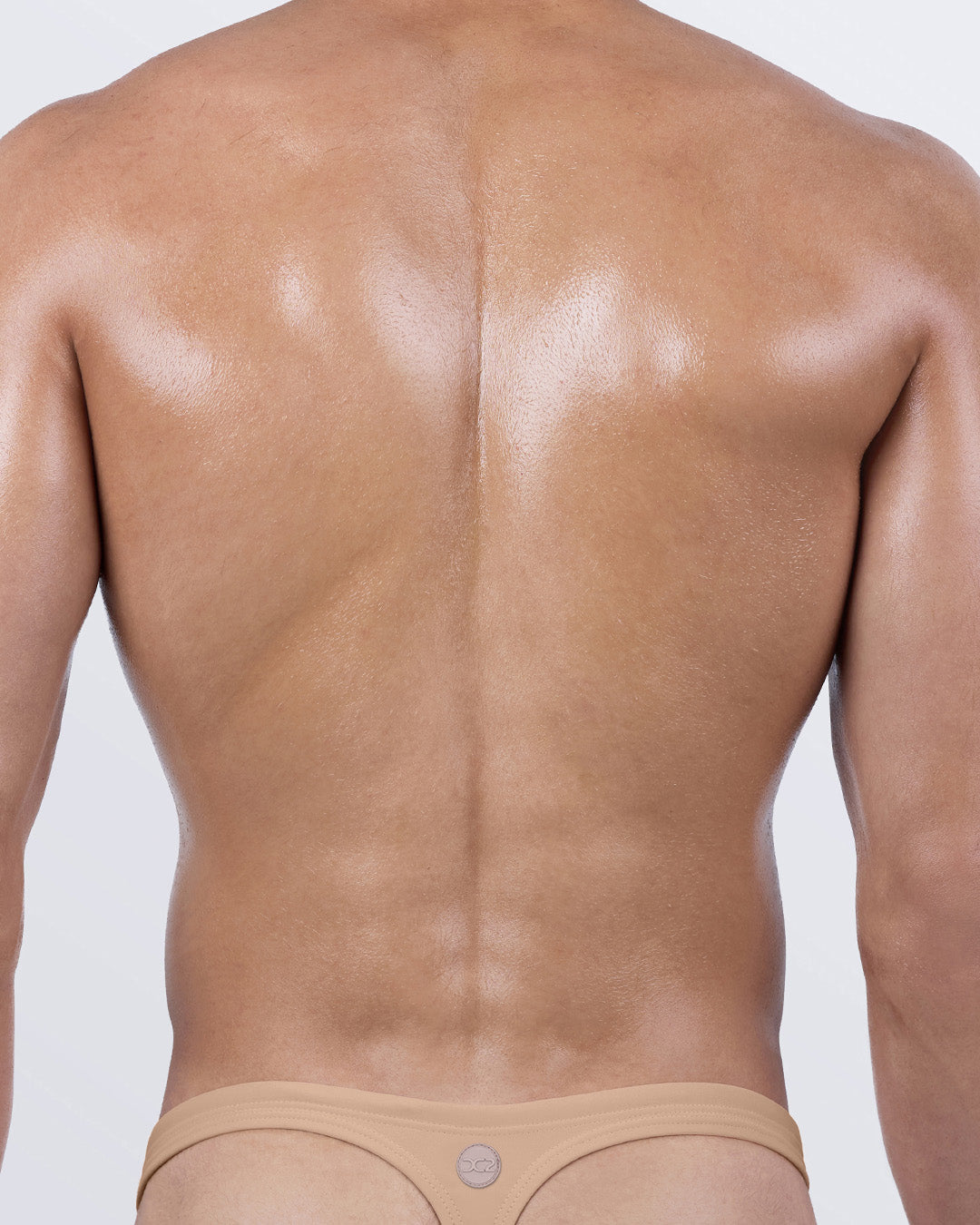 Back view of DC2 BANG Skinny Dip (Medium) swim thong – tan colored men's thong swimsuit with signature T-back fit.
