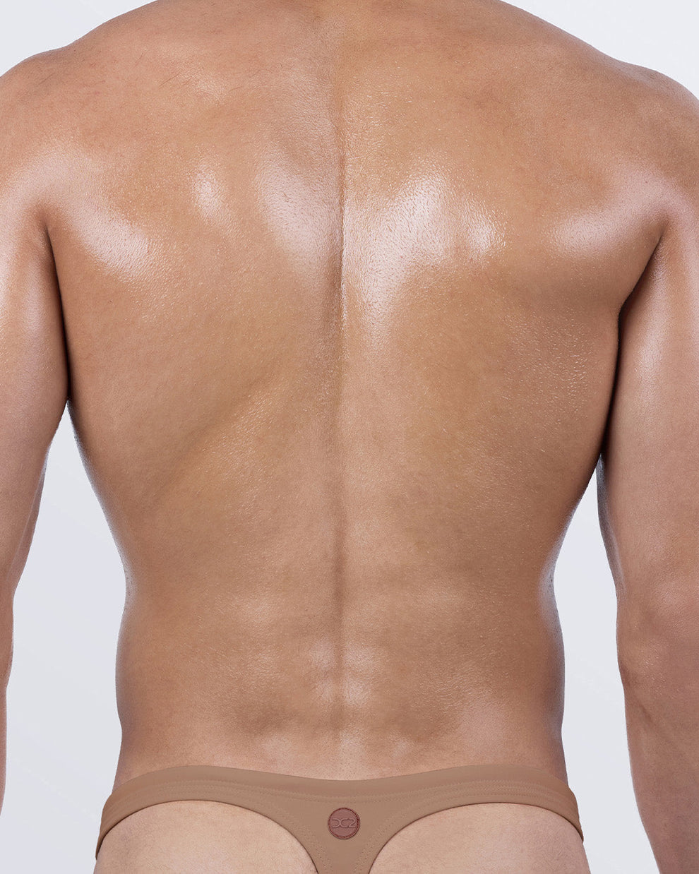 Back view of Skinny Dip (Tan) men’s thong swimsuit – T-back design for bold tan lines and premium contour fit.