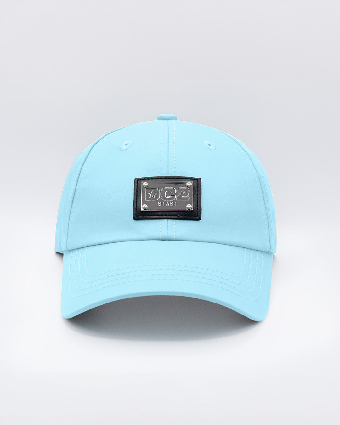 Close-up of a SKY BLUE Baseball Cap with polished DC2 metallic silver plaque.