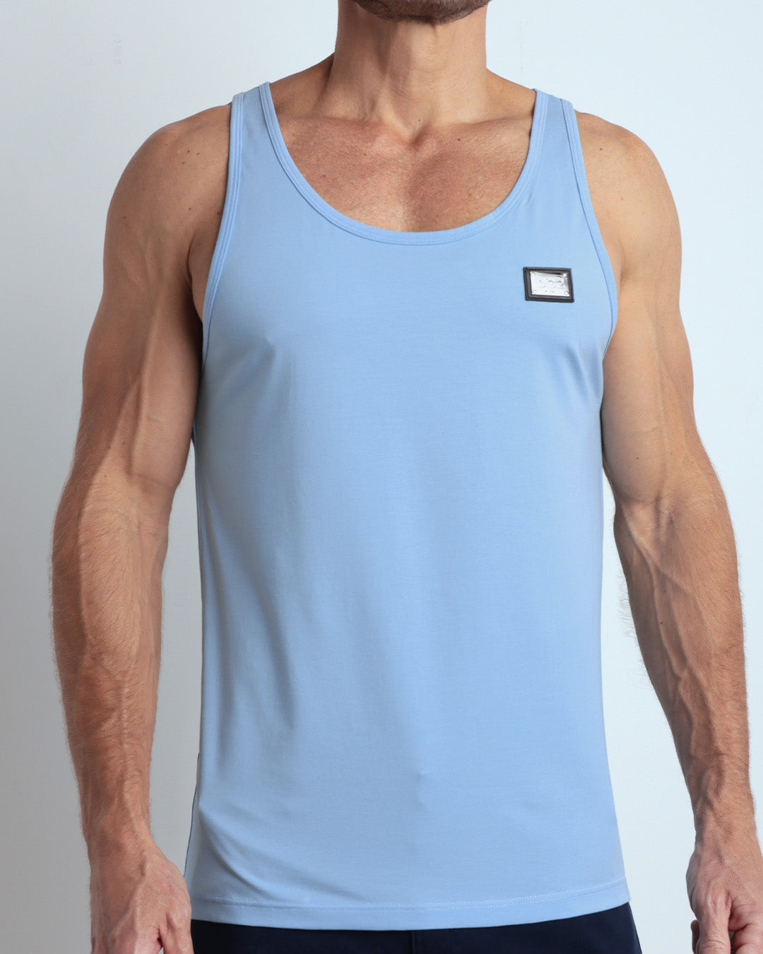 Frontal view of male model wearing the SKY BLUE in a bright, clear sky blue color casual gym tank top for men by the DC2 brand of men's beachwear from Miami.