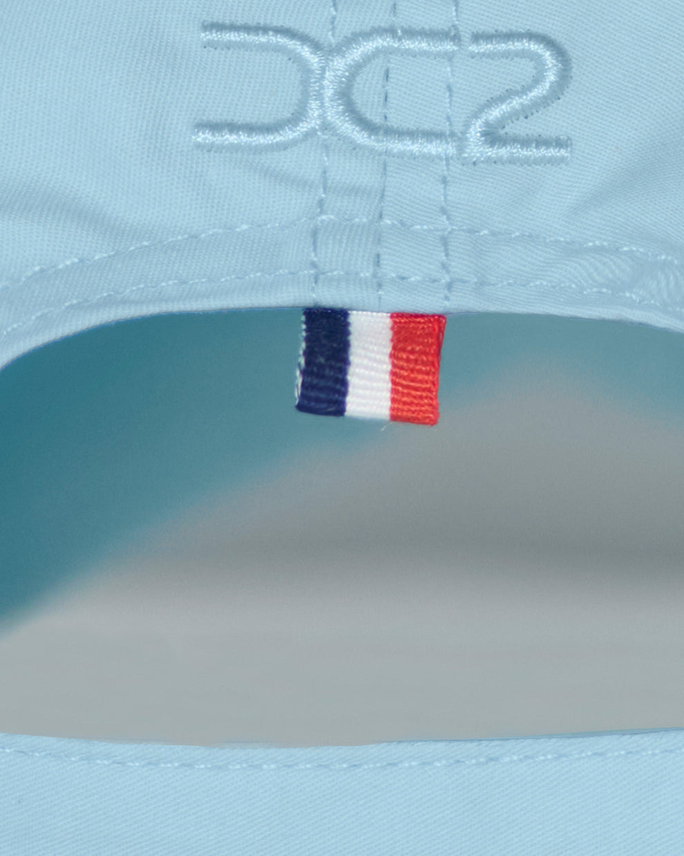 Back detail of the DC2 Resort Cap in Sky Blue — featuring tonal stitching and a woven tricolor accent tab.

