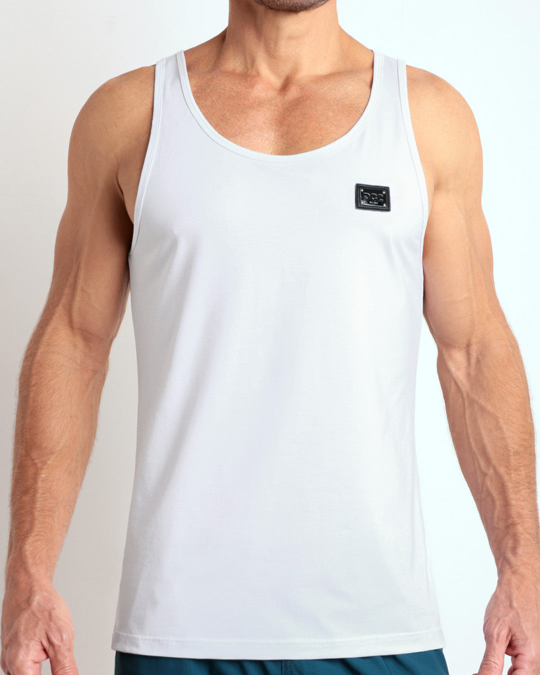 Frontal view of male model wearing the SOFT WHITE in a solid white color casual gym tank top for men by the DC2 brand of men's beachwear from Miami.