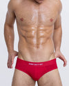DC2 SOME LIKE IT HOT — model wearing bright red modal briefs, featuring “SOME LIKE IT HOT” text on waistband and sculpted front pouch.