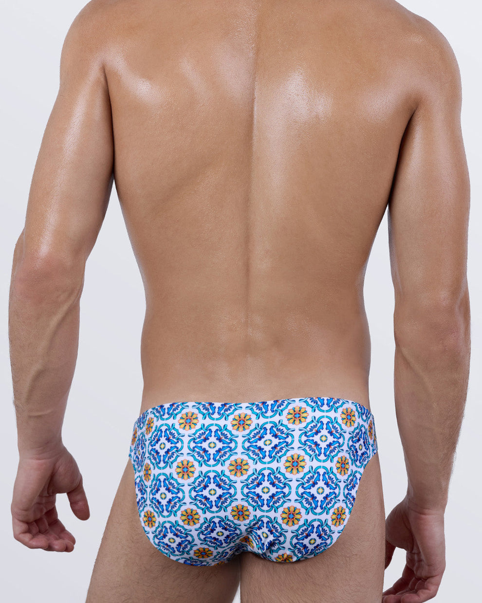 Back view of THE TILE IS HIGH swim mini briefs for men. This bold, luxury micro bathing suit features a tile mosaic pattern for a Mediterranean vibe, cut for a daring yet comfortable fit. Ideal for elevated resort swim style.