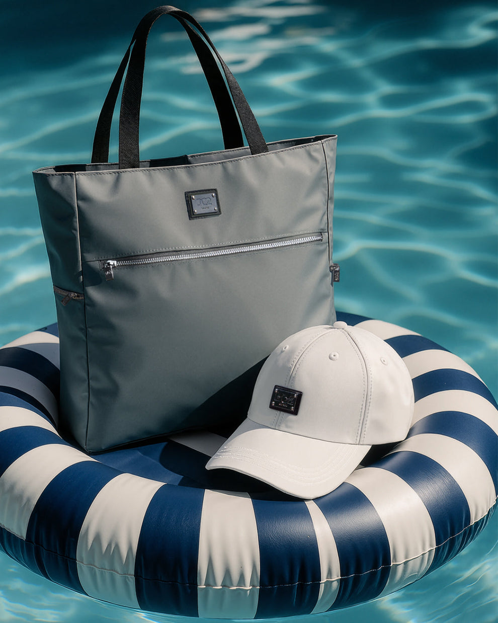 DC2 Vacay Gray Poolside Tote and White Chillax Cap — sleek summer essentials featuring a waterproof tote with zip pocket and lightweight structured cap with logo patch.