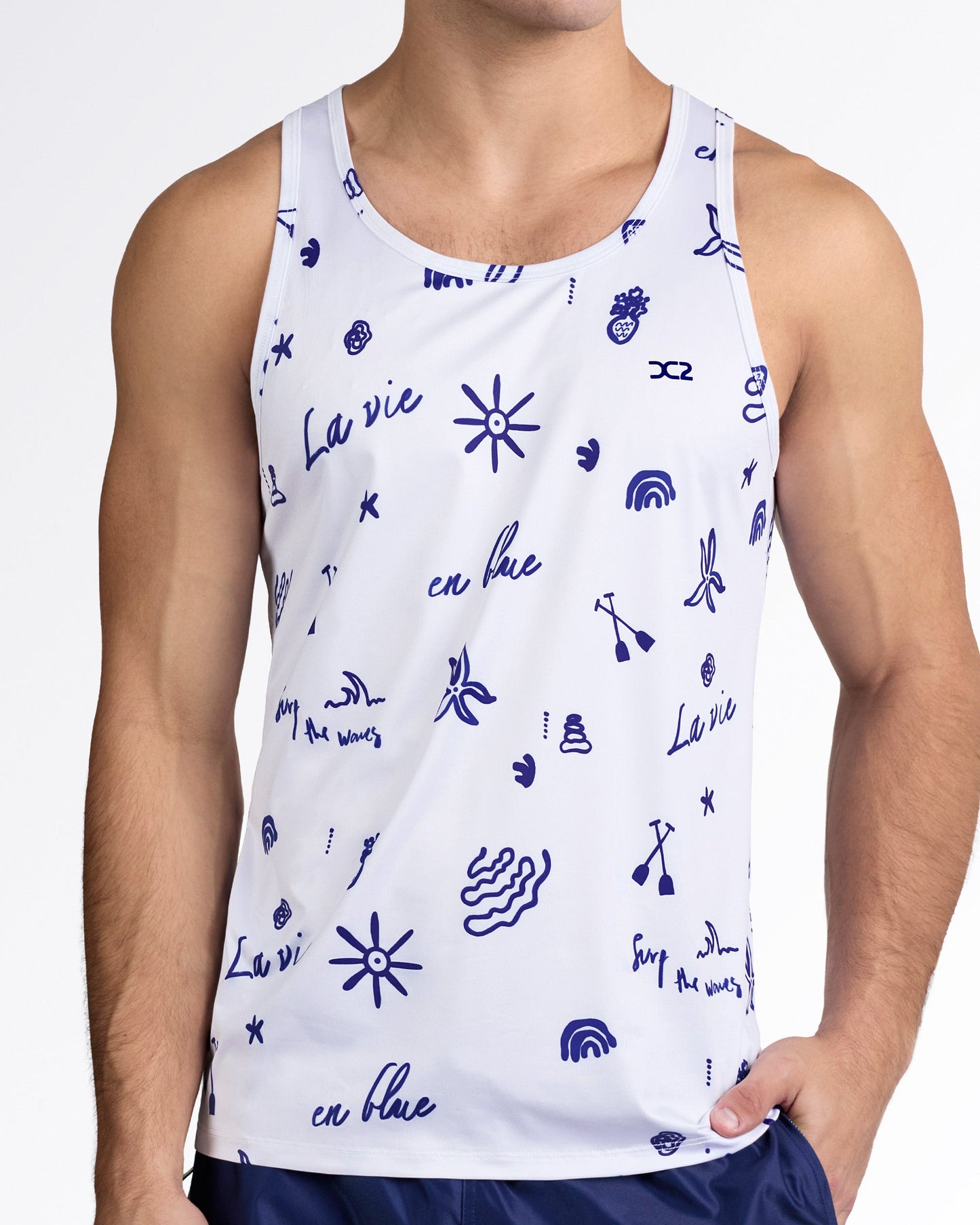 DC2 Viva La Vida (Blue) Gym Tank Top — model wearing light grey men’s tank with navy blue graphic print featuring sun, wave, and “La vie en blue” illustrations.