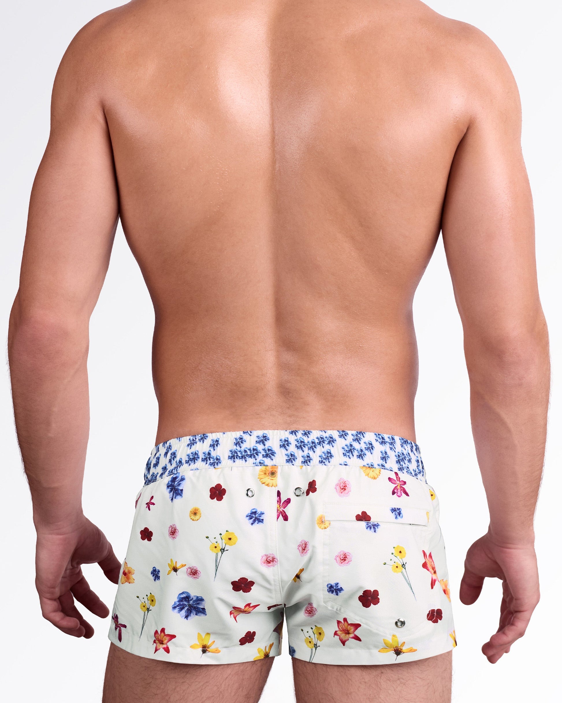 BANG Flower Powers (Cream) Mini Shorts — back view showcasing the vibrant flower pattern, elastic waistband, metal drainage eyelets, and a functional rear pocket for style and practicality.