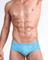 BANG! Viva La Vida (En Rose) Swim Brief — front view featuring soft pink graphic illustrations and handwritten text on a turquoise blue base with low-rise tailored fit.