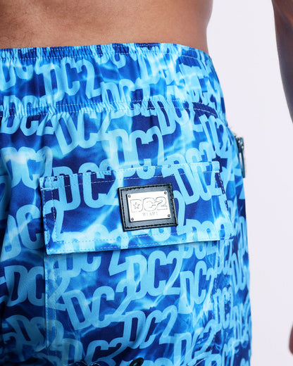 Close-up view of the WET men’s Flex Shorts back pocket, showing custom branded silver metal logo.