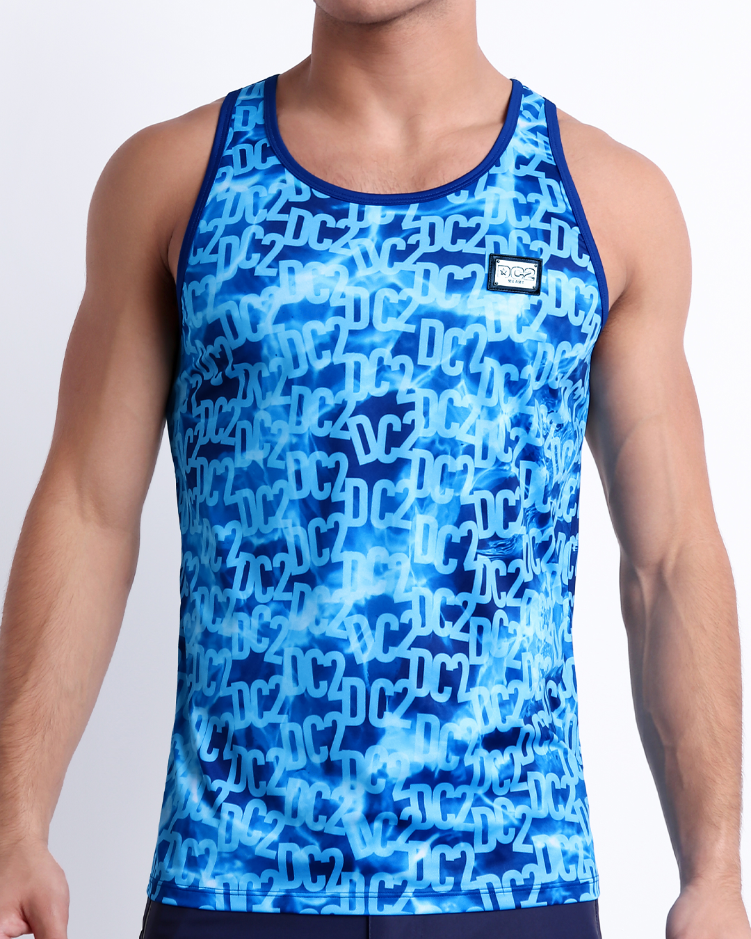 Male model wearing WET men’s casual Tank Top. A premium quality top with stylish DC2 logo monogram motif in blue, a men’s beachwear brand from Miami.