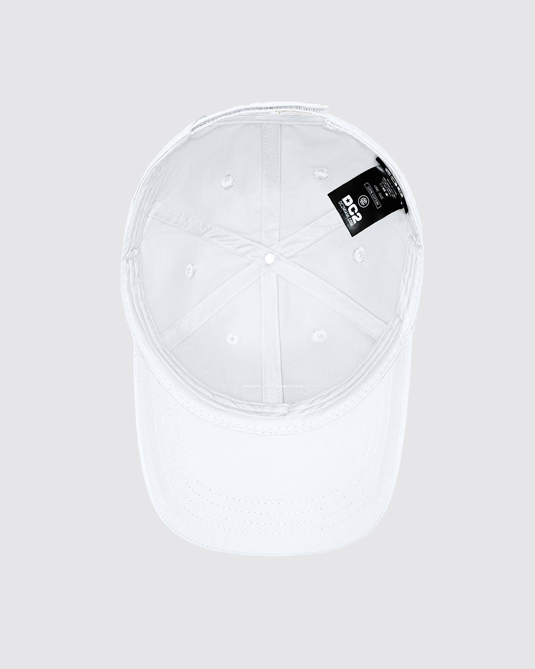 Overhead view of the inside of the WHITE Chillax baseball cap. The cap is crafted from durable white fabric with a soft inner band for a comfortable fit. Visible stitching lines and a branded label from DC2 Miami, making it an ideal accessory for casual wear and street style.