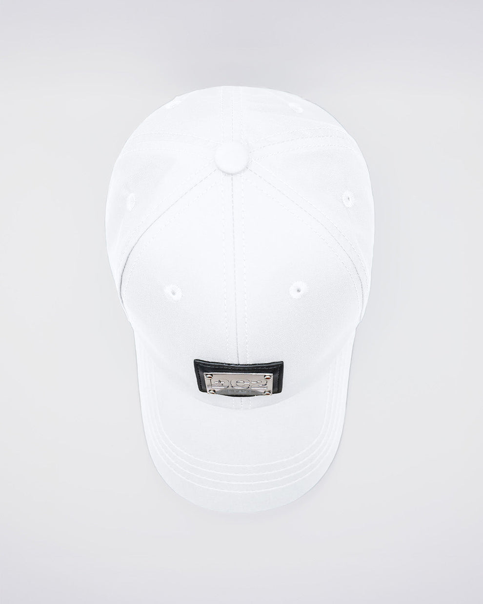 Close-up of a WHITE Baseball Cap with polished DC2 metallic silver plaque. Features ventilation eyelets on the cap to provide extra breathability, perfect for active wear.