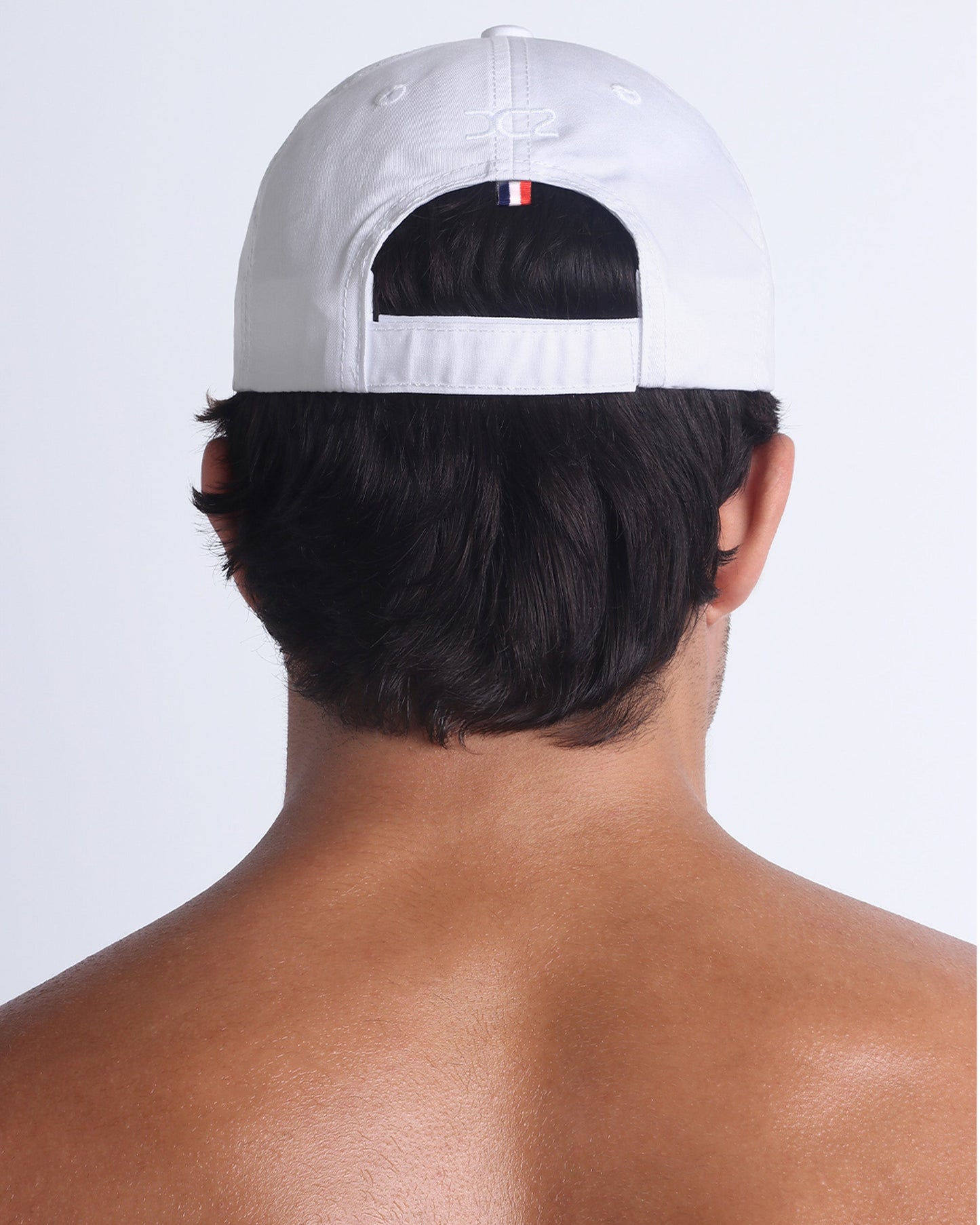 Back view of DC2 white resort cap, adjustable strap closure with a clean, modern finish.
