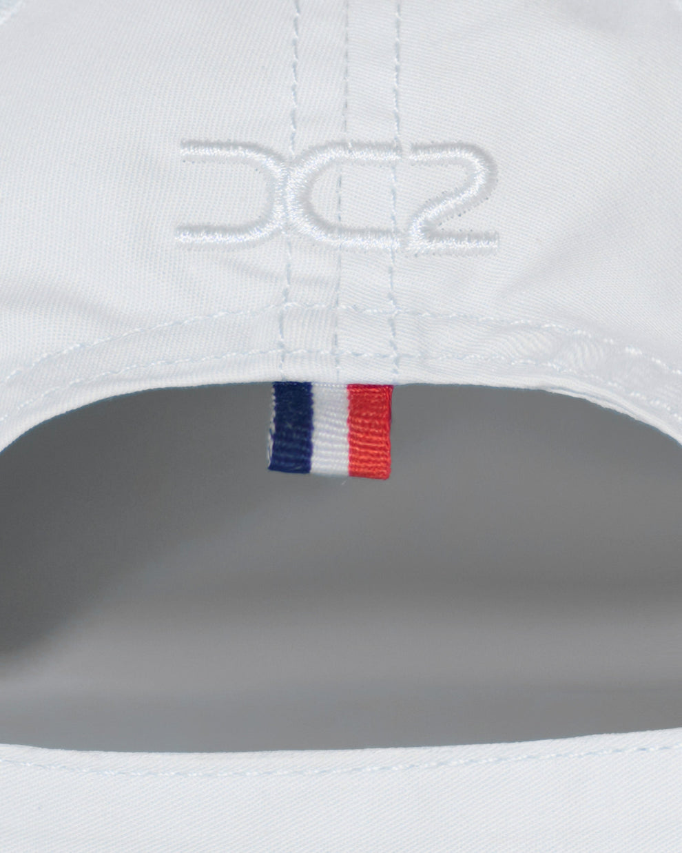 Back detail of the DC2 Resort Cap in White — featuring tonal stitching and a woven tricolor accent tab.
